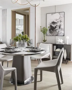 A modern dining room with a round table, white leather chairs, and a modern art piece on the wall.