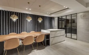 A modern kitchen featuring wooden dining tables, marble countertops, and metallic accents.