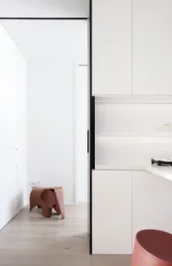 Modern minimalist residential kitchen with sleek white cabinets and clean lines.