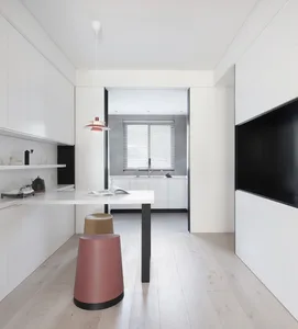 Modern minimalist kitchen featuring white laminate cabinets and stainless steel appliances.