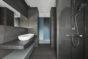 A modern bathroom with a concrete sink and floor.