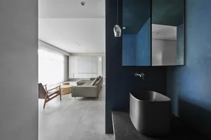 A modern living room with concrete walls and a minimalist sofa.