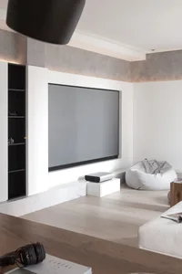 A minimalist home theater with a large projection screen, projector, and comfortable seating.