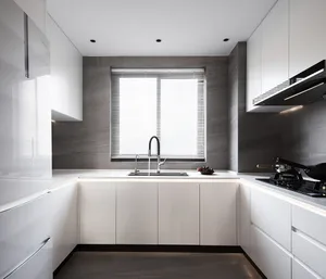 A modern minimalist kitchen with white cabinets and gray marble tile countertops, featuring a sleek sink and contemporary app