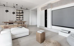 Modern minimalist living room featuring white cabinets, oak flooring, and wooden furniture.