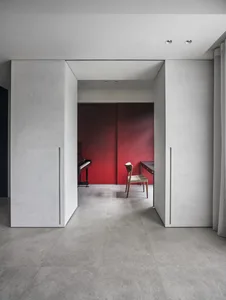 An image of a modern office space with a minimalist design, featuring a desk, chair, and a piano.