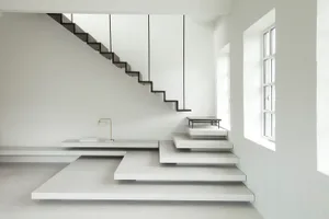 Modern minimalist interior design featuring a concrete staircase with floating steps and a simple, elegant lamp.
