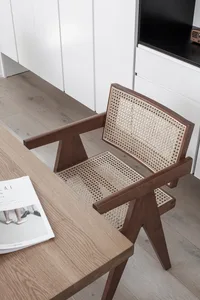 A minimalist office setting featuring a wooden and woven cane chair.