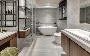 A modern bathroom interior with a concrete surface, featuring a freestanding bathtub, walk-in shower, and wooden vanities.