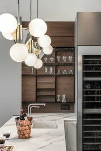 Modern kitchen with white marble countertops, black wood accents, and a built-in appliance.