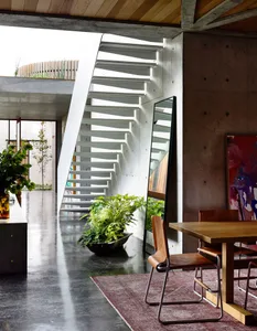 An image of a modern interior space featuring concrete walls and wood furniture.