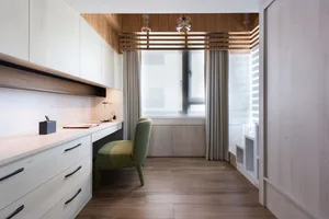 A modern office space with wooden elements and a green chair.