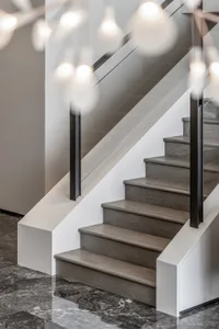 A modern staircase with wooden steps, glass railings, and a concrete base.