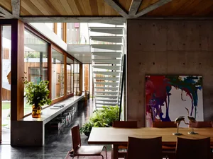 工業風極簡住宅餐廳，搭配混凝土牆面、玻璃元素與木質家具。