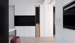 Modern interior design featuring minimalist white cabinets with black accents in a contemporary apartment setting.