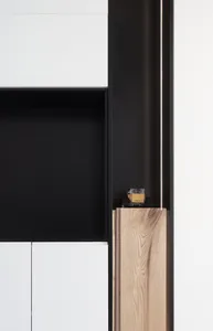 A minimalist cabinet with white, black, and wooden elements.