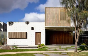 Modern residential home with concrete exterior and wooden accents on the upper level.