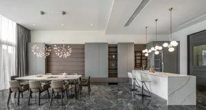 Modern minimalist living room with marble accents, featuring a sleek dining table and contemporary lighting fixtures.