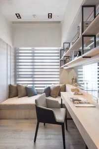 Contemporary home office setup with wooden furniture, built-in shelves, and a comfortable seating area with cushions.
