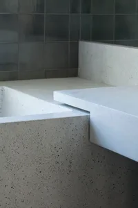 A minimalist bathroom featuring concrete walls and flooring.