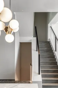 Modern staircase with wooden steps and glass railings.