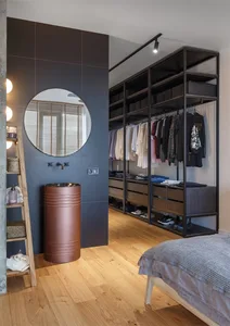 Modern industrial closet with steel shelves and wooden closet doors.