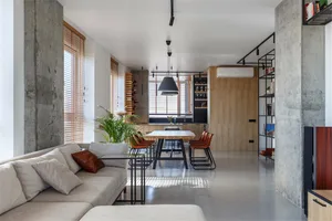 Industrial living room with concrete walls, wooden accents, and minimalist furniture.