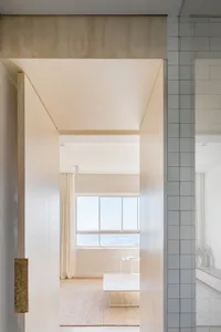 Interior design with minimalist style featuring a white space with minimal furniture and large windows.
