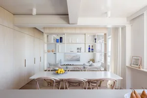 A minimalist residential space featuring white wood finishes and clean lines.