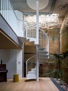 A minimalist white metal spiral staircase