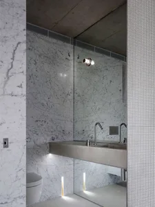 Modern bathroom features luxurious marble walls and floor with sleek, minimalistic design.