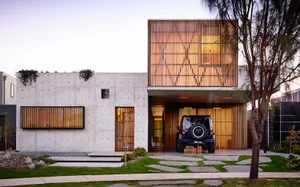 A modern, minimalist house with a concrete facade, wooden accents, and glass windows and doors.,