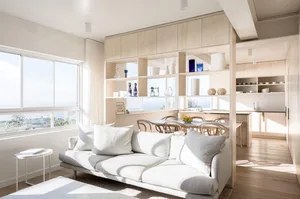 A modern minimalist living room featuring a white couch and a wood wall with open shelving.