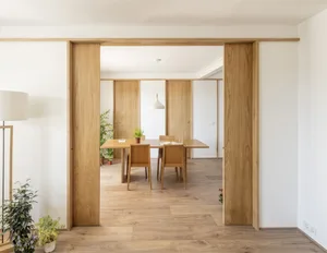 Modern industrial dining room with wooden furniture and green plants.
