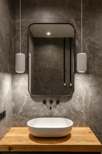 Modern bathroom featuring a marble countertop with a white sink and a large rectangular mirror hanging above.