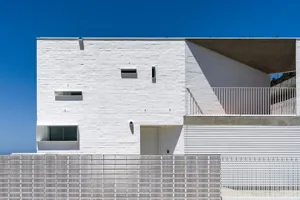 A modern building facade with concrete walls and a white brick wall.