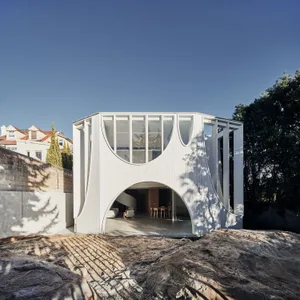 Modern building with metal and glass exterior featuring curved architectural design.