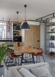 Modern dining room with wooden furniture, black pendant lights, and a mix of leather and metal chairs.