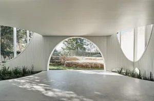 Modern exterior space with concrete flooring and wooden structures.