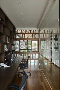 A modern home office featuring wooden furniture and large windows.