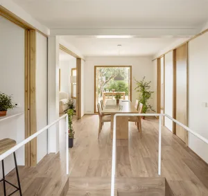 Modern minimalist living space with white walls and wooden flooring.