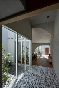 An entryway with concrete walls and a patterned tile floor, showcasing minimalist design elements.
