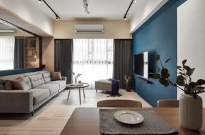 Modern minimalist living room with gray sofa, wooden coffee table, and large windows.
