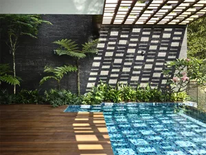 A modern swimming pool with blue tiled interior and brick walls.