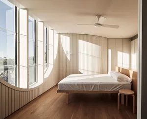 Modern bedroom featuring a wooden bed and floor with large windows