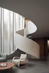 Modern interior design featuring a sleek, minimalist concrete staircase with large windows.