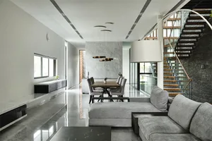 Modern living and dining space featuring marble and concrete finishes, stainless steel accents, and contemporary furniture.