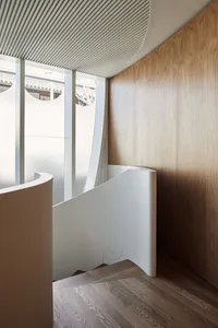 Modern staircase with white composite materials and wooden wall.