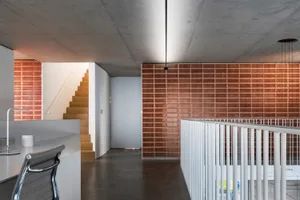 An office space featuring modern brick and concrete materials with lighting fixtures.