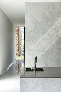 A modern kitchen featuring a white marble backsplash and countertop.